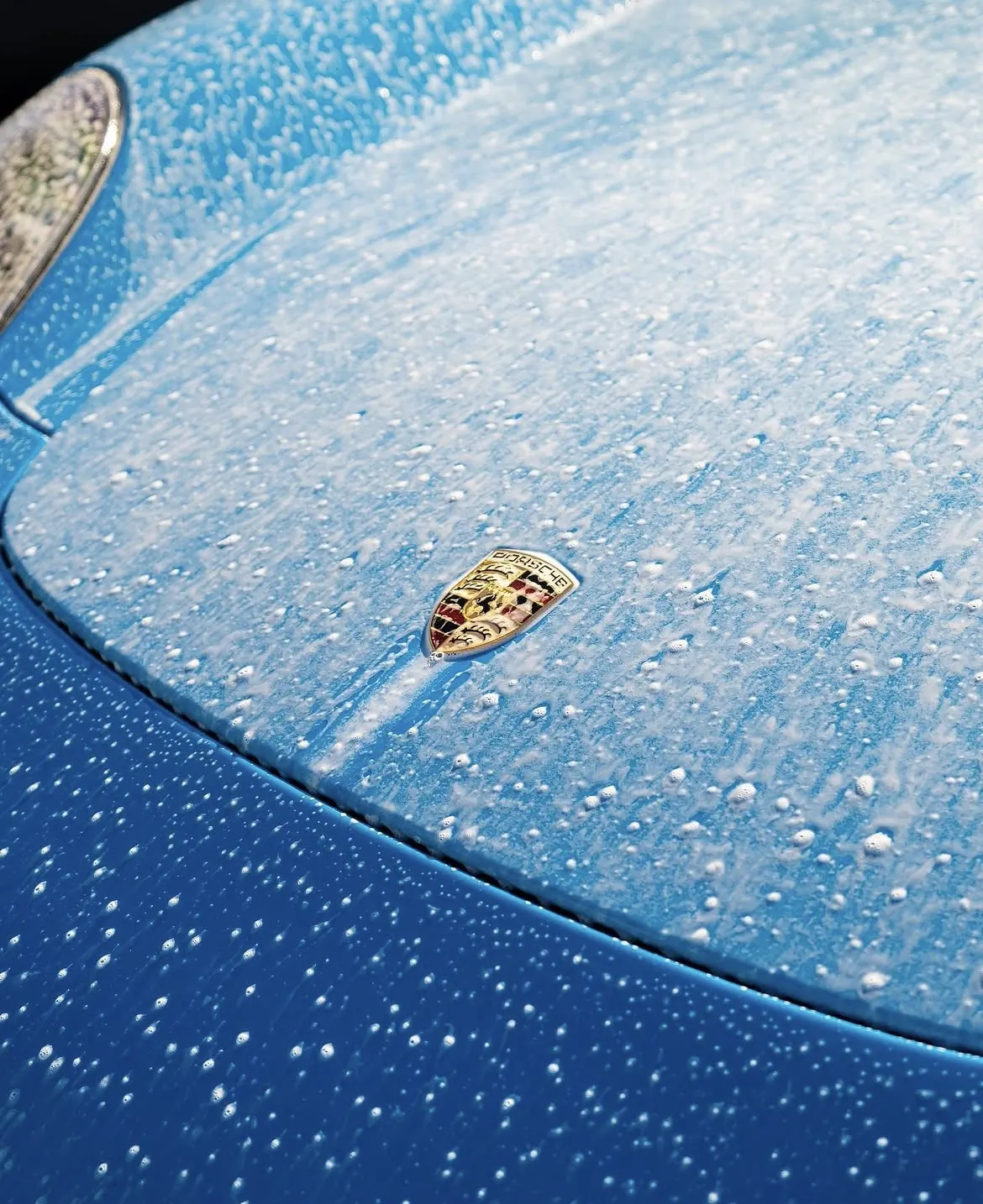 Porsche badge foam bath close-up